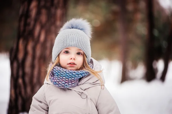 Winter-Porträt von niedlichen Baby-Mädchen zu Fuß im verschneiten Wald in warmem Outfit — Stockfoto