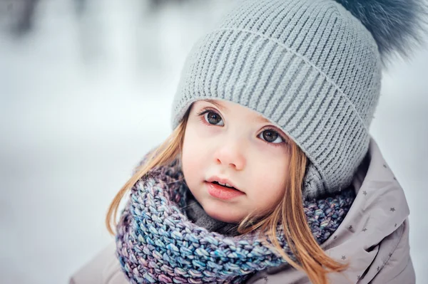 Portret zimowy cute dziewczynka chodzenie zewnątrz w śnieżnym lesie w ciepły strój — Zdjęcie stockowe
