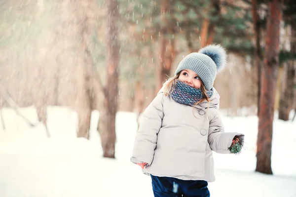 Söt glad baby flicka promenader i vinter skog — Stockfoto