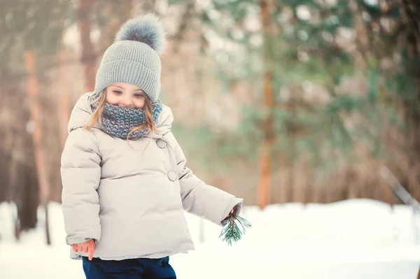 Bonito menina feliz caminhando na floresta de inverno — Fotografia de Stock