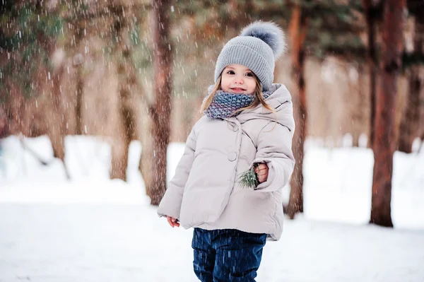 cute happy baby girl walking in snowy winter forest, spending Christmas vacations outdoor