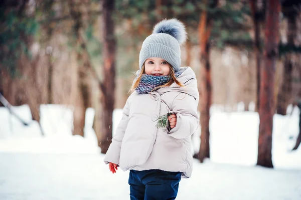 Carino felice bambina a piedi nella foresta invernale — Foto Stock