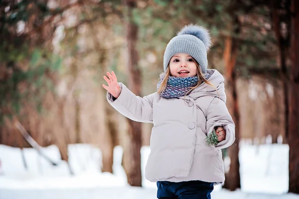 Carino felice bambina che cammina nella foresta invernale innevata, trascorrere le vacanze di Natale all'aperto — Foto Stock