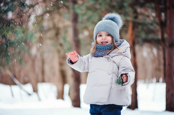 Söt glad baby flicka promenader i vinter skog — Stockfoto