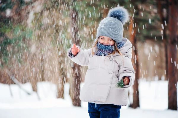 Cute happy baby girl walking in winter forest — Stock Photo, Image