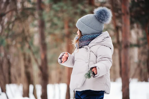 Söt glad baby flicka promenader i vinter skog — Stockfoto