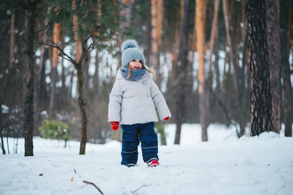 Cute happy baby girl walking in winter forest — Stock Photo, Image