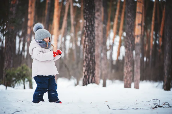 Cute happy baby girl walking in winter forest — Stock Photo, Image