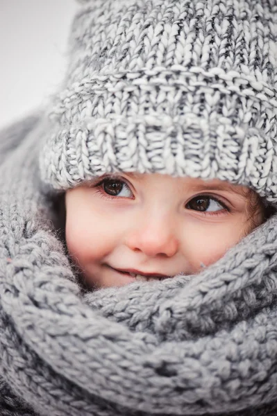 Χειμώνα πορτρέτο του όμορφο κοριτσάκι σε θερμή υπερμεγέθης πλεκτά κασκόλ και καπέλο με τα πόδια στο χειμώνα χιονισμένο δάσος — Φωτογραφία Αρχείου
