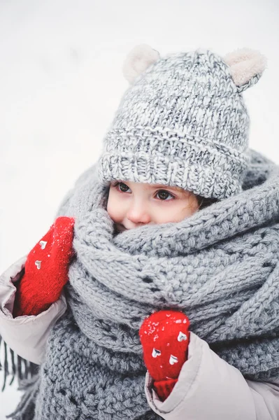 Vinter porträtt av söt baby flicka i oversize grå stickad halsduk promenader i snöig skog — Stockfoto