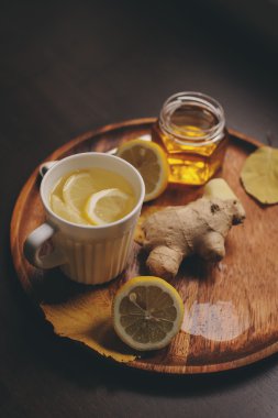 zencefil, limon ve bal sıcak çay karanlık rustik iç pişirme. Malzemeler ve ahşap arka plan üzerinde Kupası
