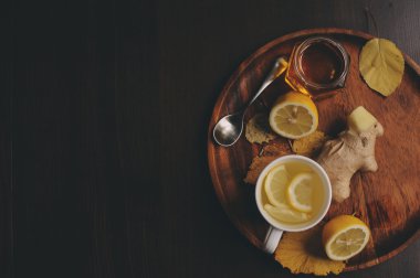 zencefil, limon ve bal sıcak çay karanlık rustik iç pişirme. Malzemeler ve ahşap arka plan üzerinde Kupası