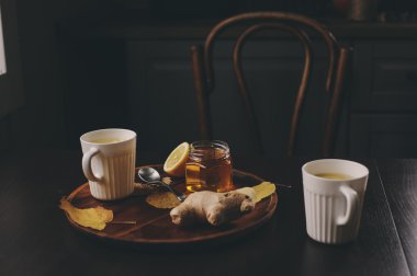 zencefil, limon ve bal sıcak çay karanlık rustik iç pişirme. Malzemeler ve ahşap arka plan üzerinde Kupası