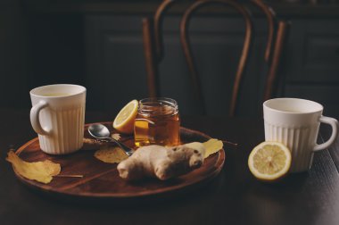 zencefil, limon ve bal sıcak çay karanlık rustik iç pişirme. Malzemeler ve ahşap arka plan üzerinde Kupası