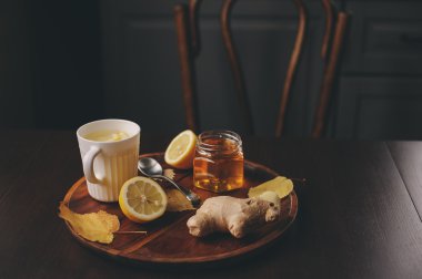 zencefil, limon ve bal sıcak çay karanlık rustik iç pişirme. Malzemeler ve ahşap arka plan üzerinde Kupası