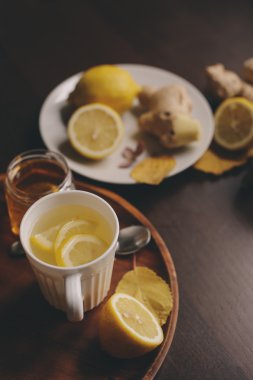 zencefil, limon ve bal sıcak çay karanlık rustik iç pişirme. Malzemeler ve ahşap arka plan üzerinde Kupası