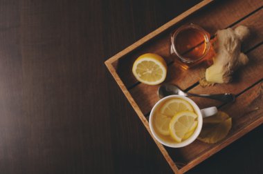 zencefil, limon ve bal sıcak çay karanlık rustik iç pişirme. Malzemeler ve ahşap arka plan üzerinde Kupası