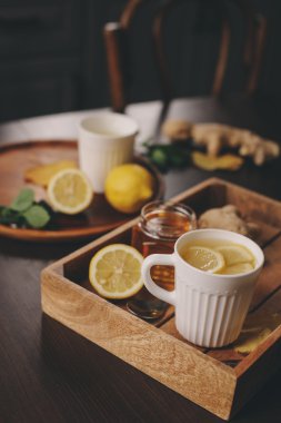 zencefil, limon ve bal sıcak çay karanlık rustik iç pişirme. Malzemeler ve ahşap arka plan üzerinde Kupası