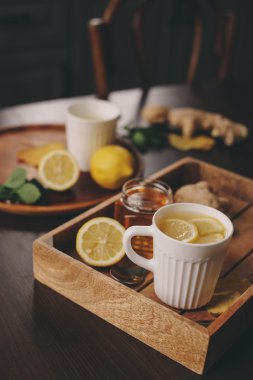 zencefil, limon ve bal sıcak çay karanlık rustik iç pişirme. Malzemeler ve ahşap arka plan üzerinde Kupası