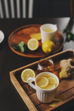 zencefil, limon ve bal sıcak çay karanlık rustik iç pişirme. Malzemeler ve ahşap arka plan üzerinde Kupası