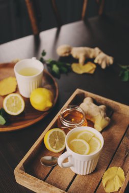 zencefil, limon ve bal sıcak çay karanlık rustik iç pişirme. Malzemeler ve ahşap arka plan üzerinde Kupası