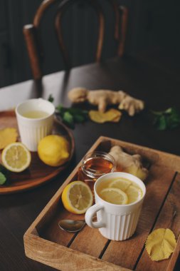 zencefil, limon ve bal sıcak çay karanlık rustik iç pişirme. Malzemeler ve ahşap arka plan üzerinde Kupası