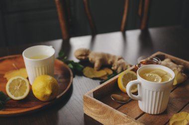 zencefil, limon ve bal sıcak çay karanlık rustik iç pişirme. Malzemeler ve ahşap arka plan üzerinde Kupası