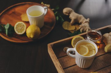 zencefil, limon ve bal sıcak çay karanlık rustik iç pişirme. Malzemeler ve ahşap arka plan üzerinde Kupası