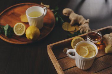 zencefil, limon ve bal sıcak çay karanlık rustik iç pişirme. Malzemeler ve ahşap arka plan üzerinde Kupası