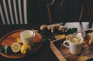 zencefil, limon ve bal sıcak çay karanlık rustik iç pişirme. Malzemeler ve ahşap arka plan üzerinde Kupası