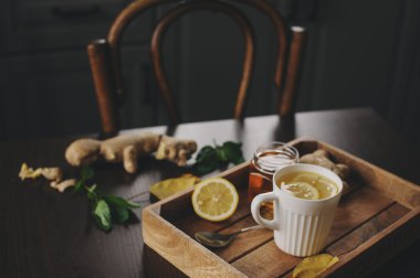 zencefil, limon ve bal sıcak çay karanlık rustik iç pişirme. Malzemeler ve ahşap arka plan üzerinde Kupası