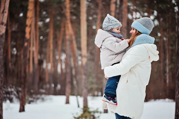 Winter portrait of cute baby girl in oversize grey knitted scarf walking in snowy forest — Stock Photo, Image