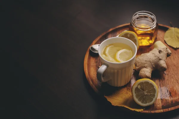 Приготовление имбиря, лимона и меда горячим чаем в темном деревенском интерьере. Ингредиенты и чашки на деревянном фоне — стоковое фото