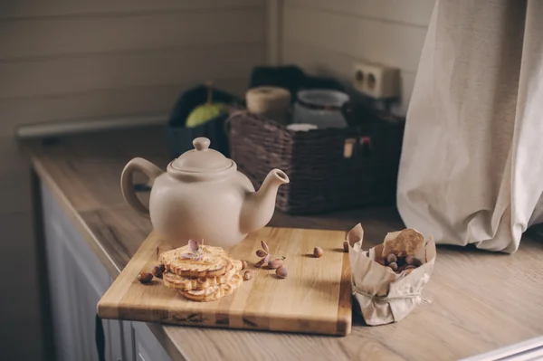 Τσάι κατσαρόλα και τα cookies στο εσωτερικό των γκρι κουζίνα σε ρουστίκ γραμμή. Αργή ζουν σε χώρα σπίτι έννοια. Ζεστό το πρωί στο σπίτι — Φωτογραφία Αρχείου