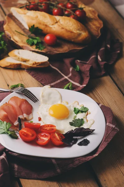 Spiegeleier mit Tomate, Basilikum und Prosciutto, gedeckter Tisch für das gemütliche Frühstück zu Hause — Stockfoto