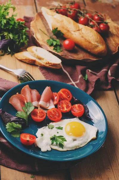 Stekta ägg med tomat, basilika och parmaskinka, tabellen för mysig frukost hemma — Stockfoto