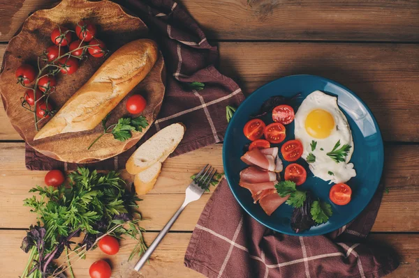 Spiegeleier mit Tomate, Basilikum und Prosciutto, gedeckter Tisch für das gemütliche Frühstück zu Hause — Stockfoto