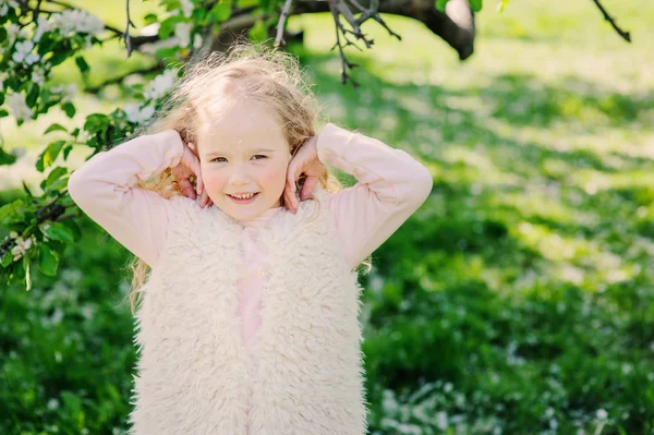 Jarní portrét krásné dítě Girl walking venkovní v rozkvetlé zahradě — Stock fotografie