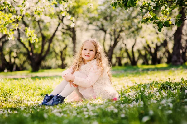 Lente portret van mooi kind meisje buiten wandelen in bloeiende tuin — Stockfoto