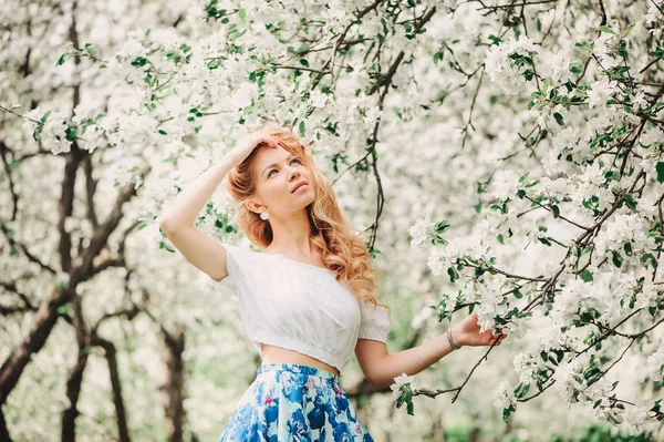 Hermosa joven en falda maxi floral caminando en primavera — Foto de Stock