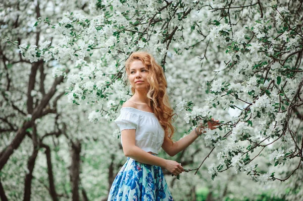 Bela jovem mulher em saia maxi floral andando na primavera — Fotografia de Stock