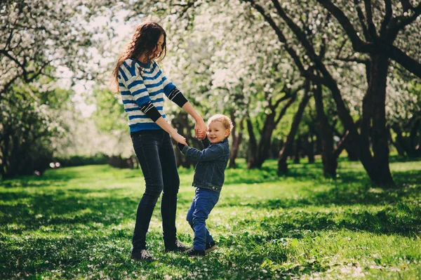 Šťastné matky a batole syn hraje venkovní v jarní nebo letní park, rodinné aktivity na procházku — Stock fotografie