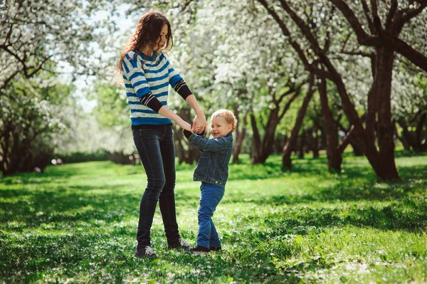 Mãe feliz e filho da criança jogando ao ar livre no parque de primavera ou verão, atividades familiares na caminhada — Fotografia de Stock