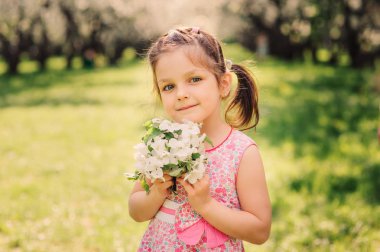 Bahar çiçek açan kiraz ile kız sevimli gülümseyen çocuk portresi