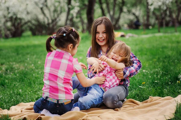 Three little sisters having a lot of fun playing together outdoor in summer park on vacation — Stock Photo, Image