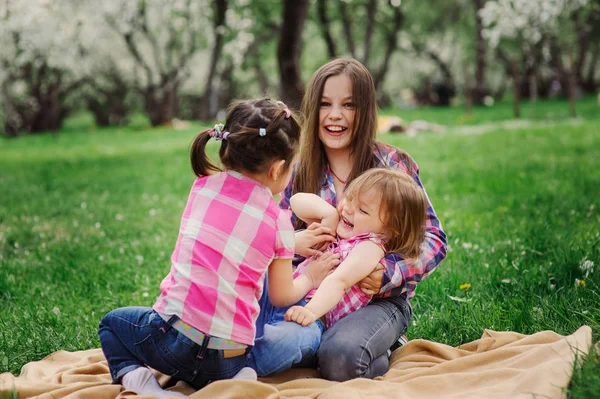 Tři sestřičky mají spoustu zábavy hraní venku v parku v létě na dovolené — Stock fotografie