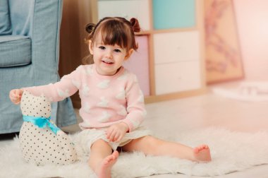 şirin mutlu 2 yıl yaşlı kız bebek evde ahşap oyuncaklar ile oynama. Modern kreş iç pastele sesleri, erken kavram öğrenme