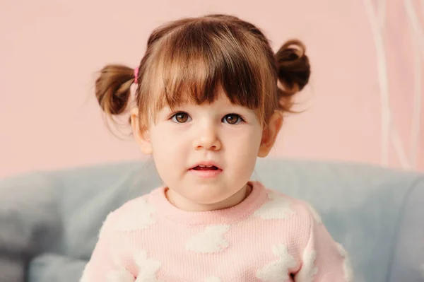 Close up indoor portrait of cute happy 2 years old baby girl in pink sweater — Stock Photo, Image