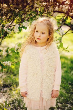 Bahar çiçek açan bahçede yürüyüş güzel rüya gibi kıvırcık 5 yaşında çocuk kız portresi