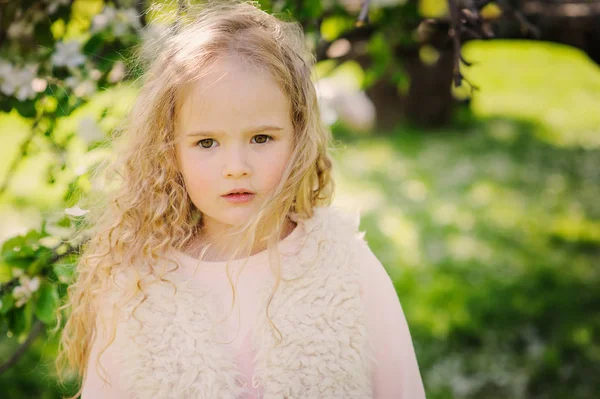 Jarní portrét krásné zasněný kudrnaté 5 let staré dítě dívka procházky v rozkvetlé zahradě — Stock fotografie